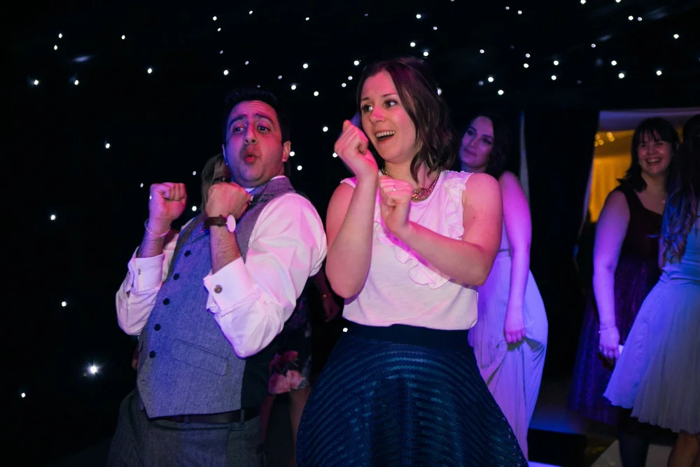 Two wedding guests dancing beneath the marquee’s star-lit ceiling