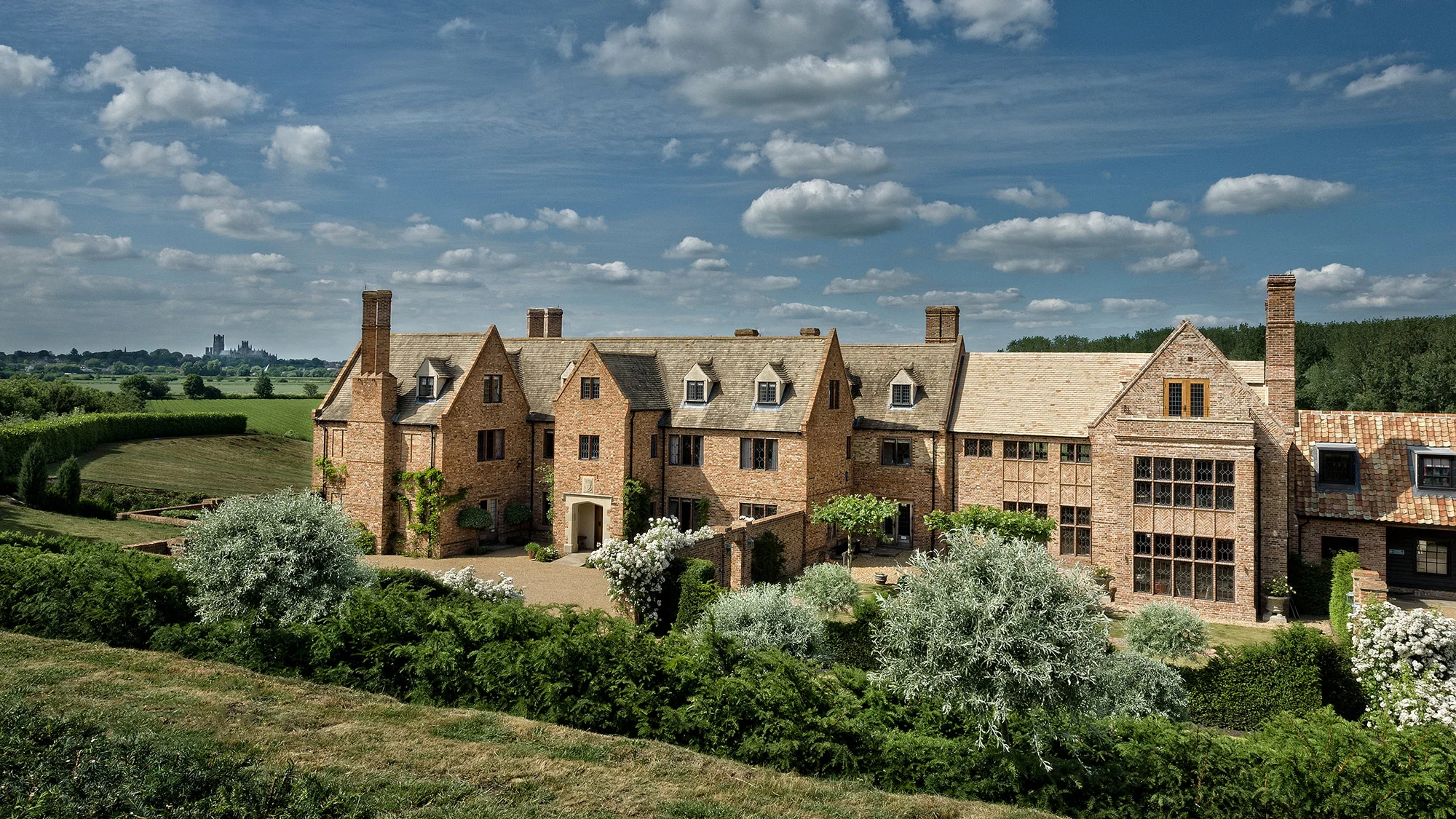 The Old Hall Ely’s brick manor house and landscaped gardens, with Ely Cathedral visible in the distance